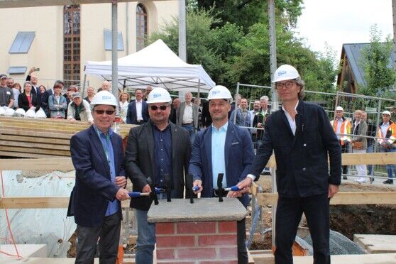 Der Museumsleiter, Stadtbaumeister, Bürgermeister und Architeckt klopfen mit Zimmermannshämmern auf den Grundstein.